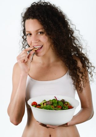 Portrait of beautiful young mixed woman with salad, isolated on white